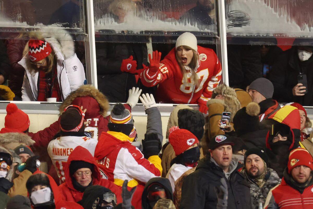 Taylor Swift celebrates with fans during the AFC Wild Card Playoffs between the Miami Dolphins and the Kansas City Chiefs