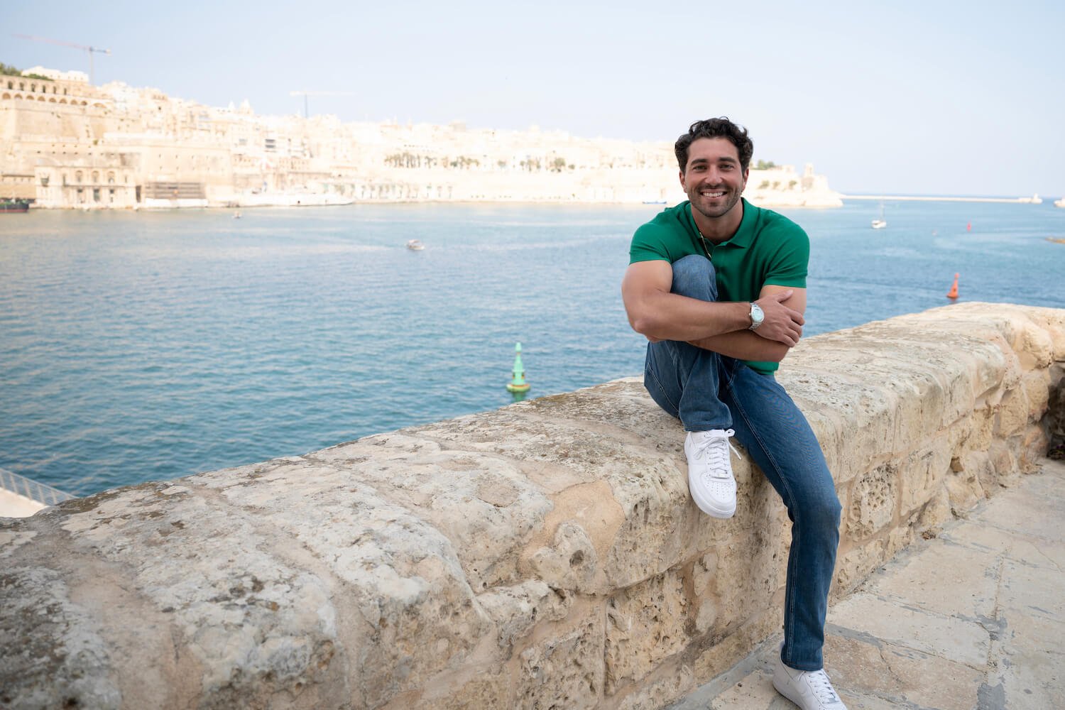Joey Graziadei sitting on a stone ledge in Malta in 'The Bachelor' Season 28