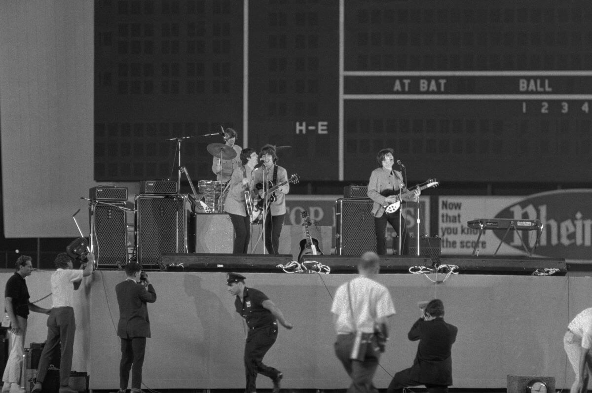 A black and white picture of The Beatles performing at Shea Stadium.