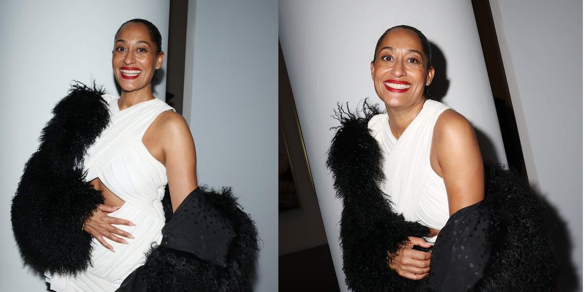 Actor wears a white gown and black furry shrug while smiling for the cameras at the Giants: Art From The Dean Collection Of Swizz Beatz And Alicia Keys