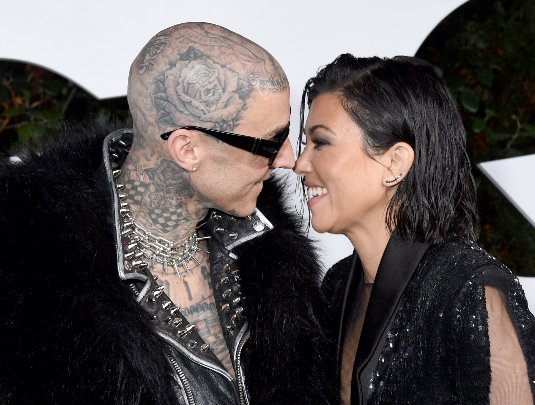 Travis Barker and Kourtney Kardashian smiling with their faces close together