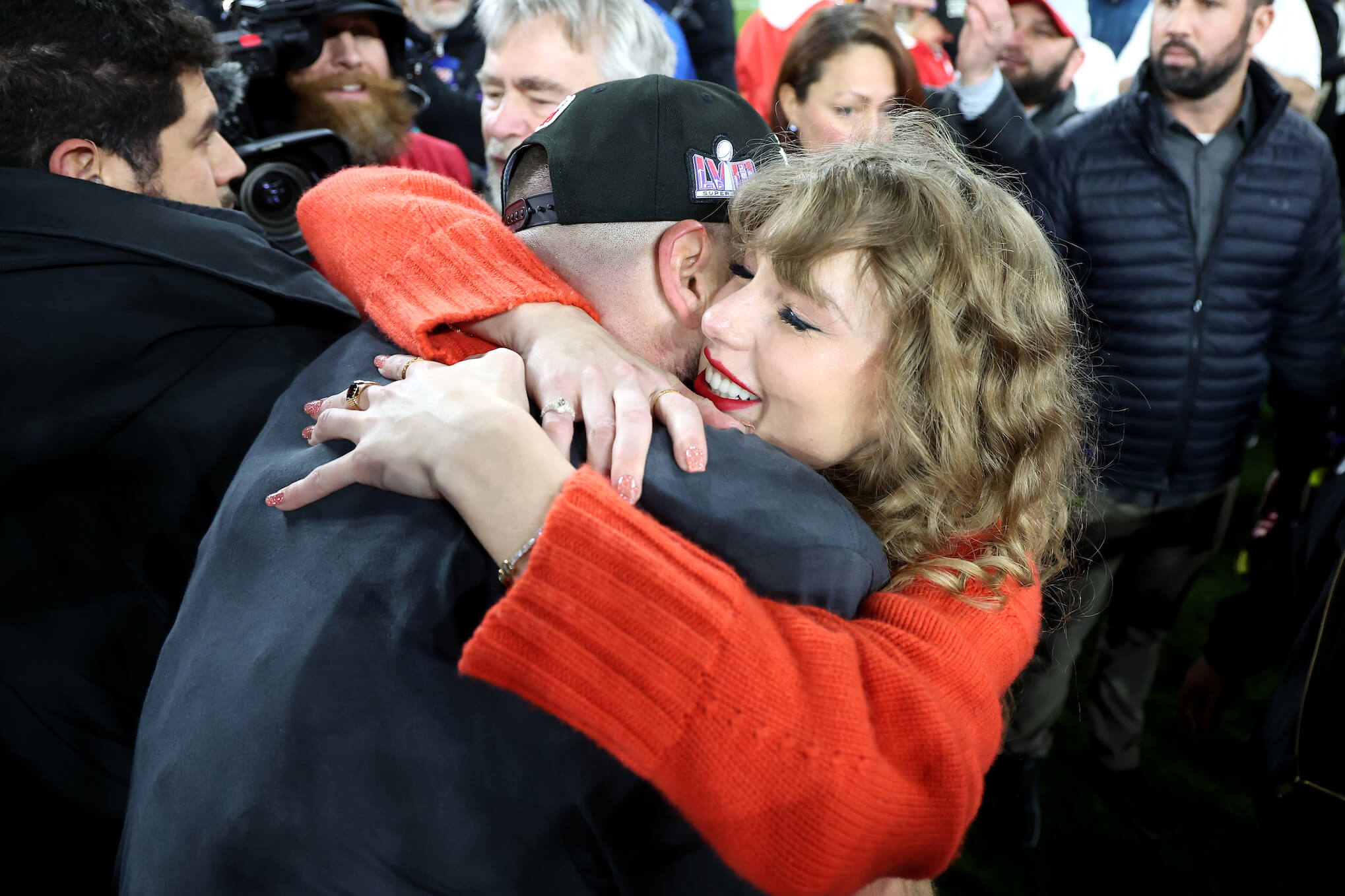 Travis Kelce and Taylor Swift embracing after a Kansas City Chiefs game