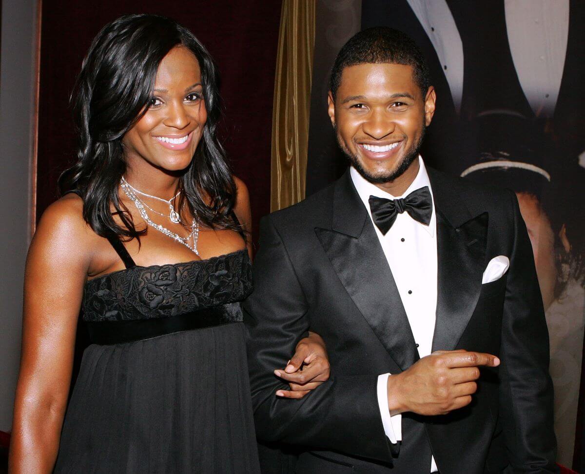 Usher wears a tuxedo and stands arm in arm with Tameka Foster, who wears a black dress.
