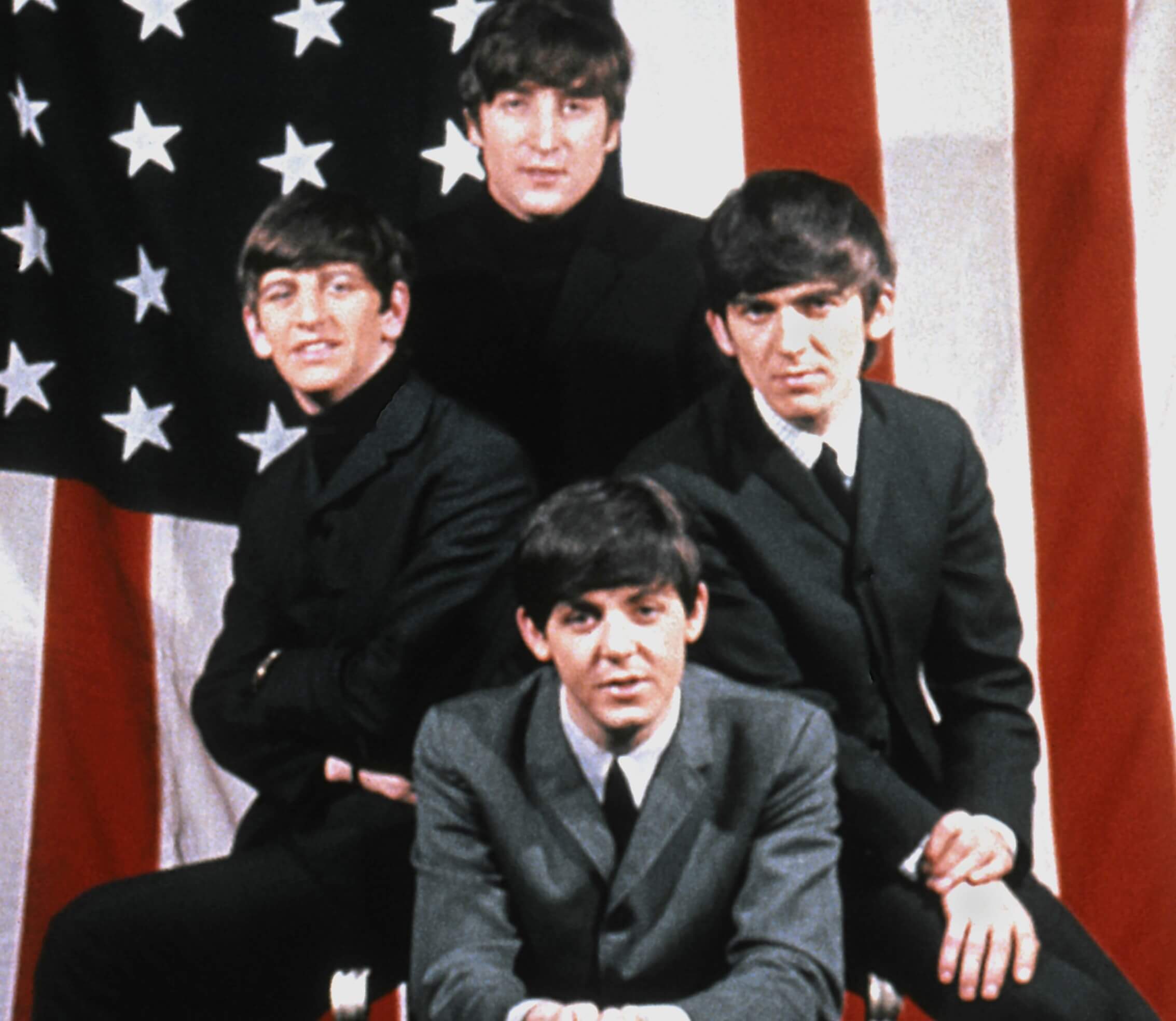 The Beatles in front of an American flag