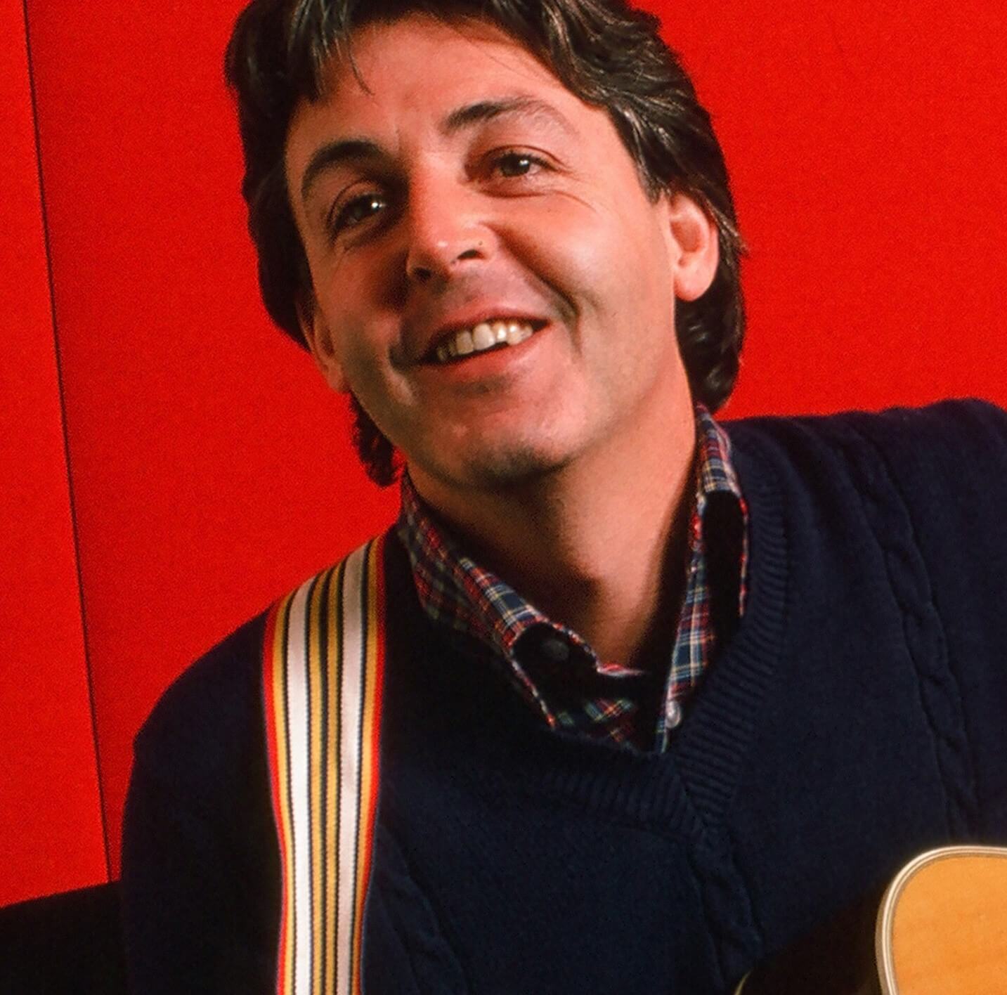 The Beatles' Paul McCartney in front of a red wall