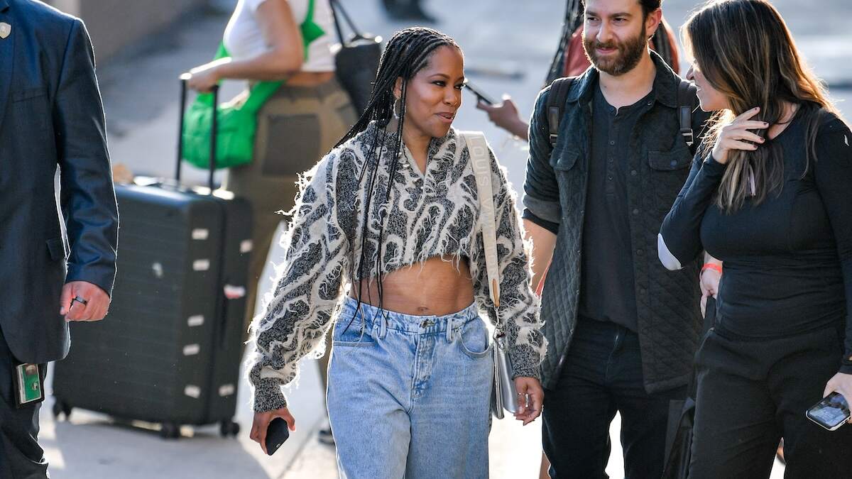 Wearing baggy jeans and a crop top, Regina King waves to fans while walking in NYC