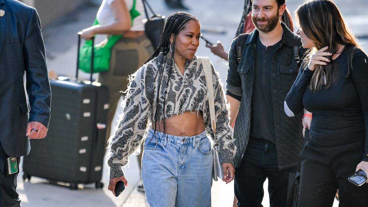Wearing baggy jeans and a crop top, Regina King waves to fans while walking in NYC