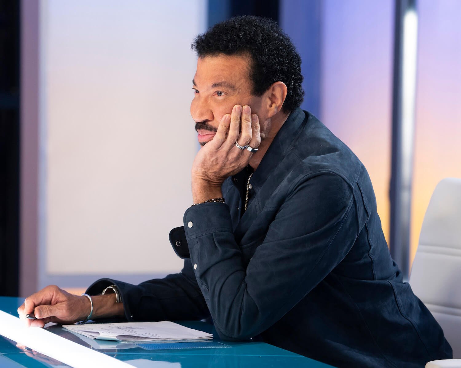 'American Idol' judge Lionel Richie with his head in his hand looking at a contestant out of frame