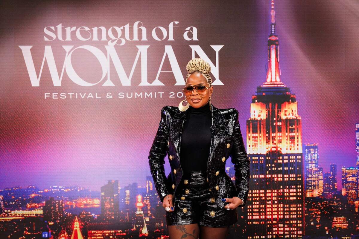 Wearing a black outfit, Mary J. Blige poses with her Strength of a Woman sign on CBS Mornings