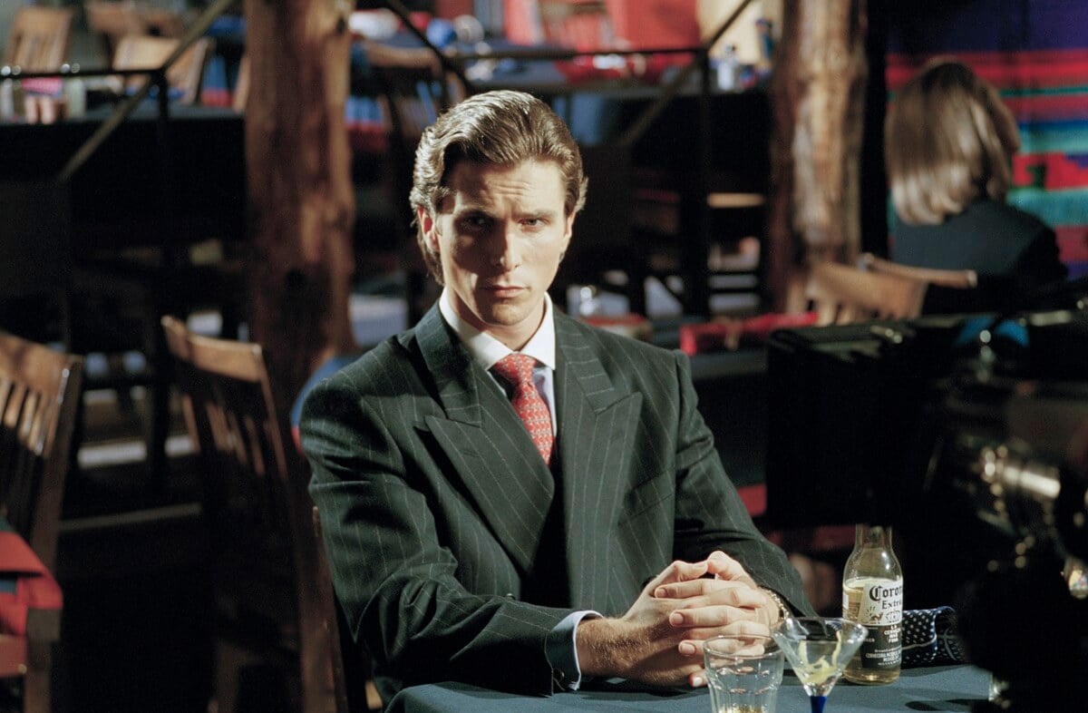 Christian Bale posing in a suit on the 'American Psycho' set.