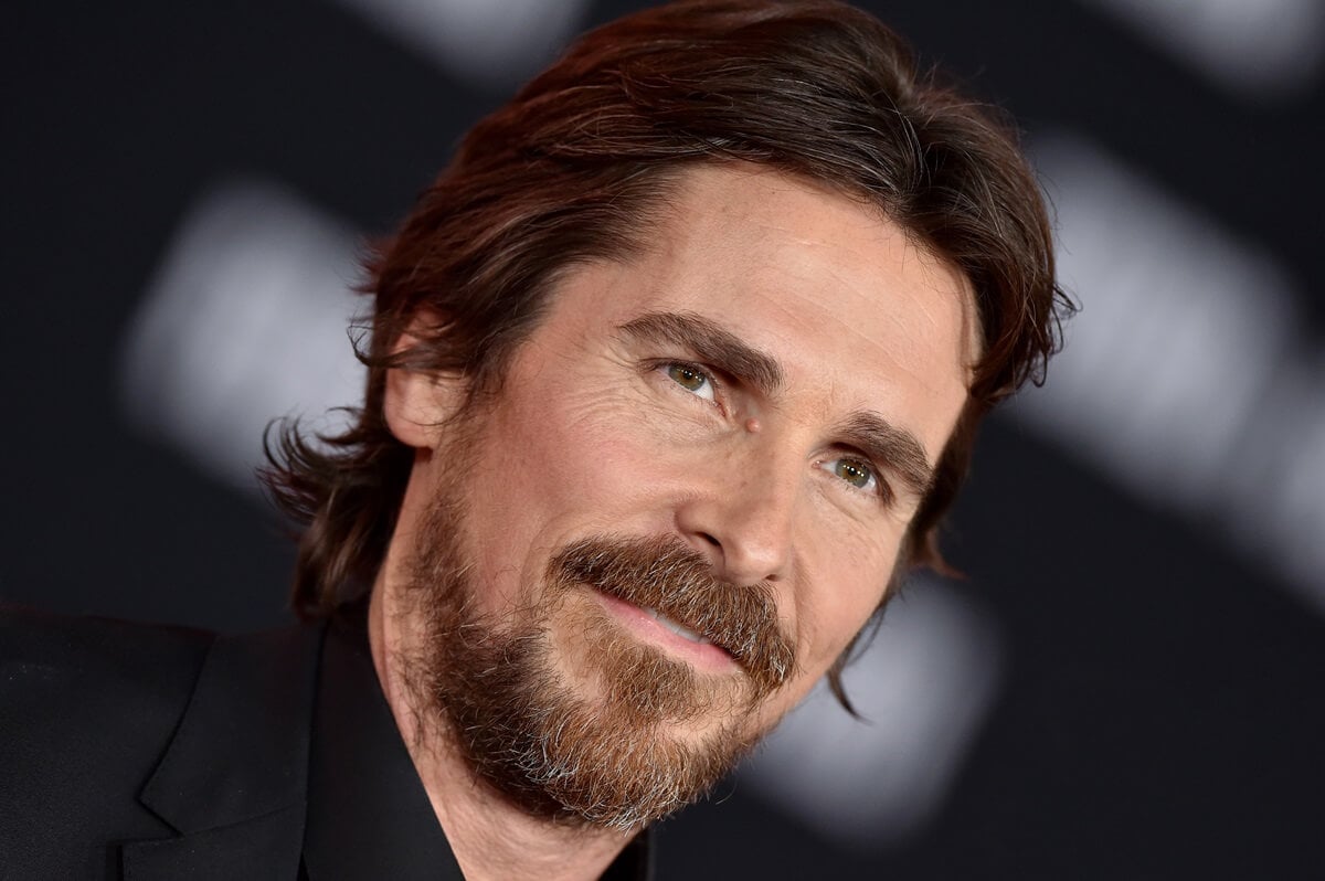 Christian Bale posing at the premiere of the Premiere of FOX's "Ford v Ferrari" in a black suit.