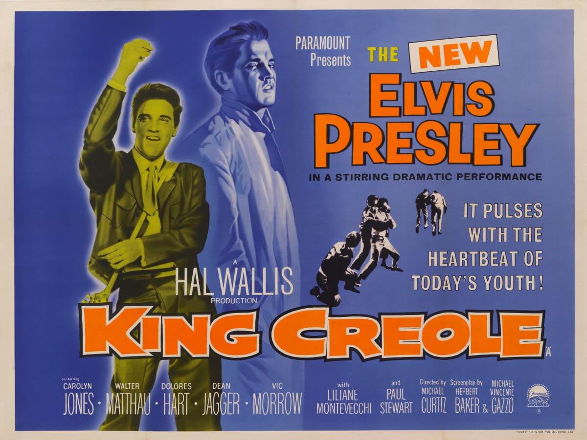 Elvis dances on a poster for the film 'King Creole.' The poster is blue and orange.