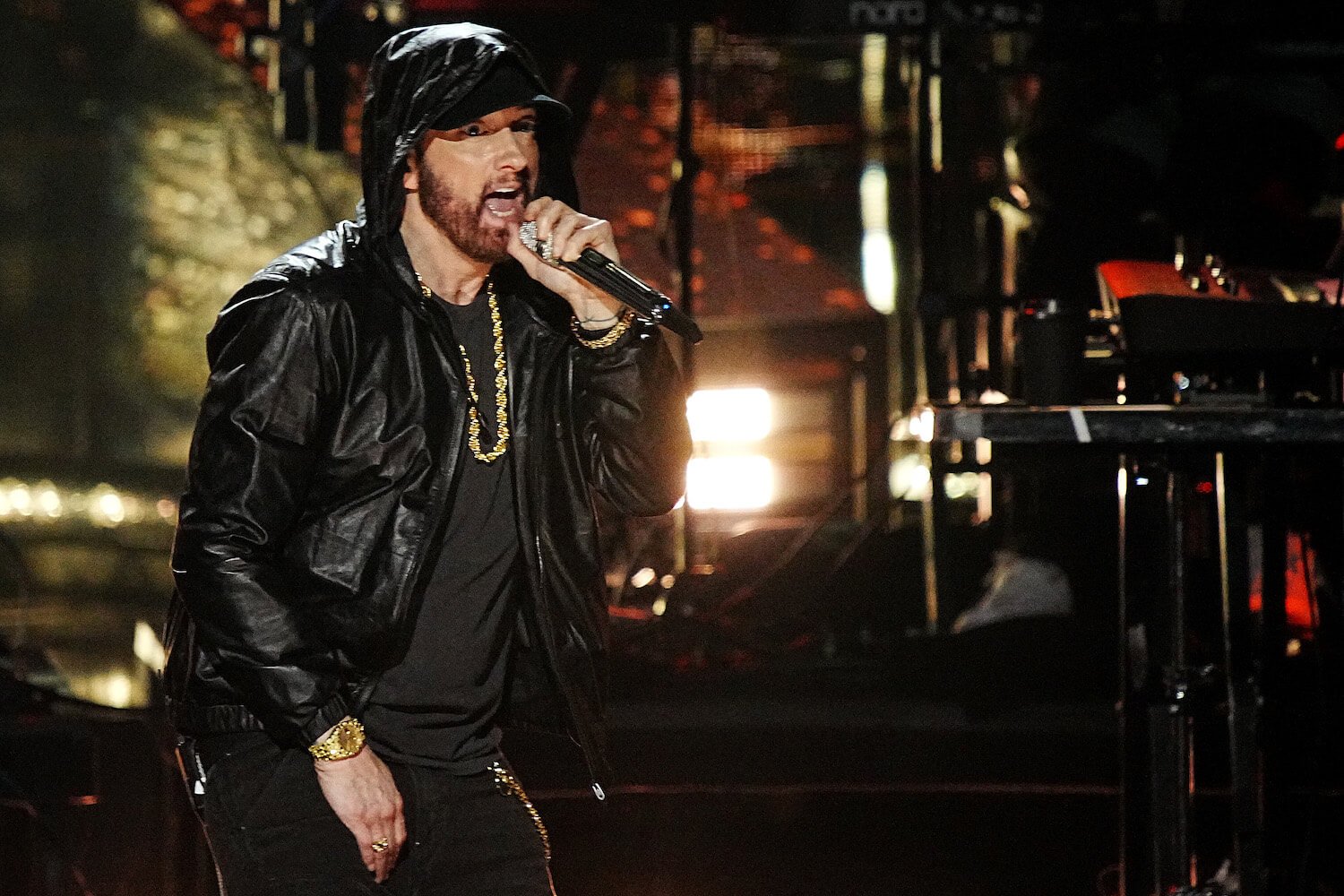 Eminem performing in a black hoodie on stage in 2022