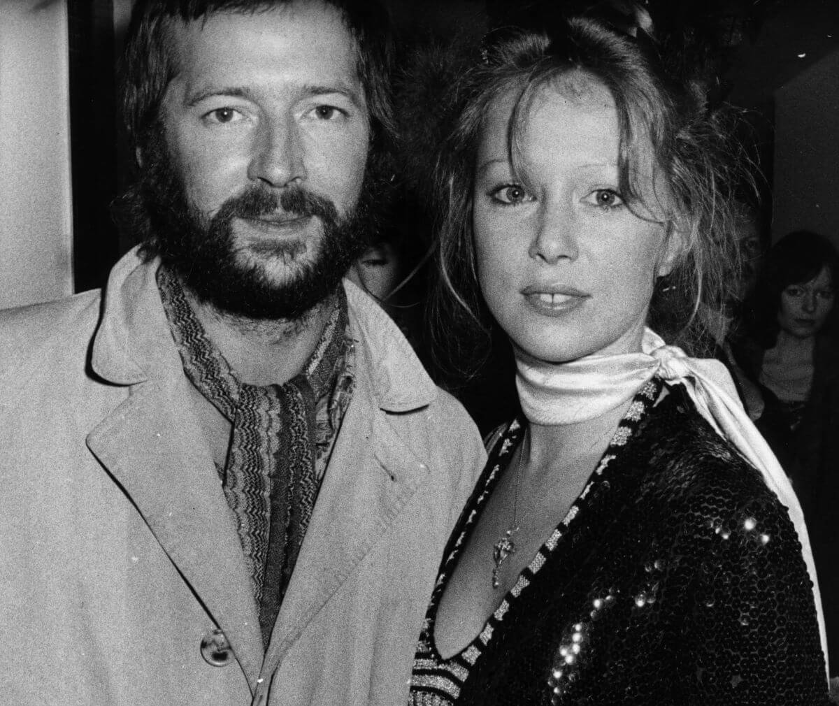 A black and white picture of Eric Clapton and Pattie Boyd. She wears a scarf around her neck.