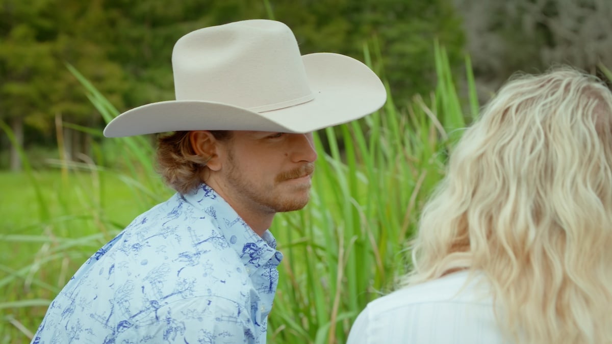Farmer Nathan wearing a white cowboy hat and talking to a blonde woman on 'Farmer Wants a Wife' Season 2