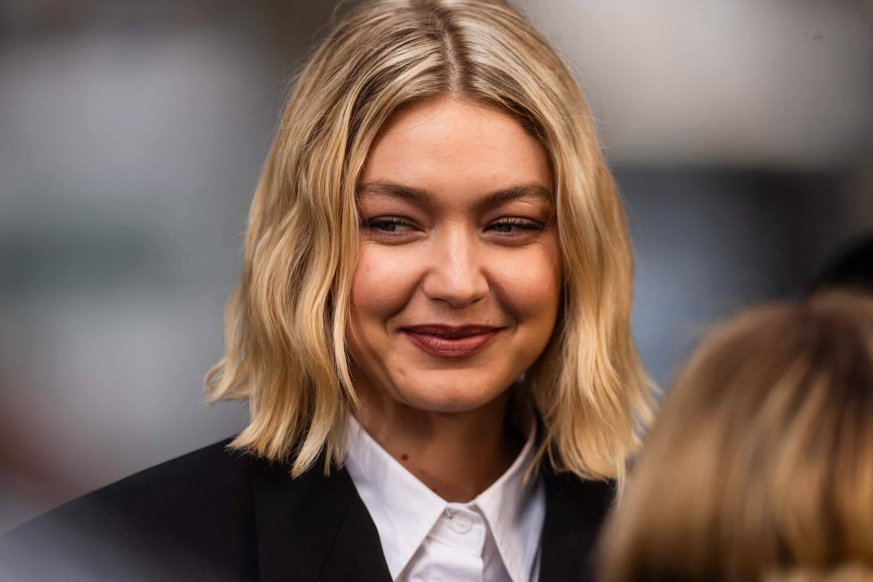 Model Gigi Hadid smiles in between takes during a Maybelline photoshoot