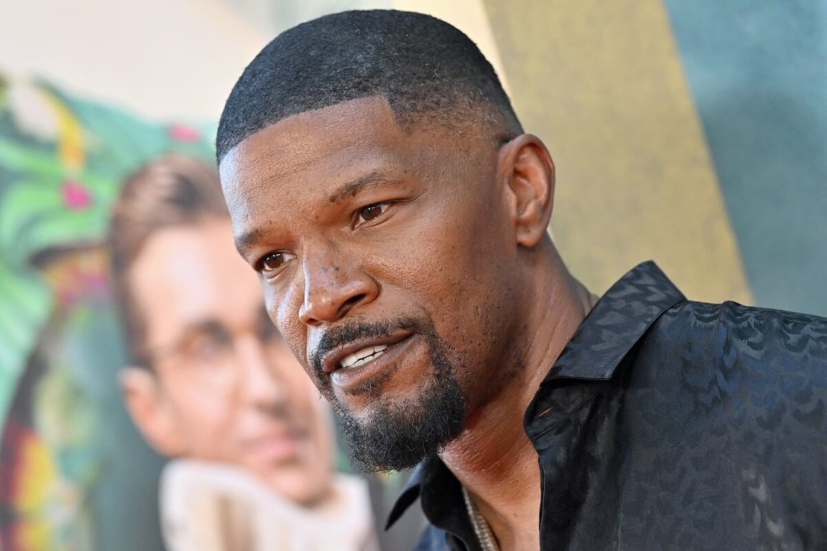 Jamie Foxx posing in a black suit at the premiere of 'Day Shift'.