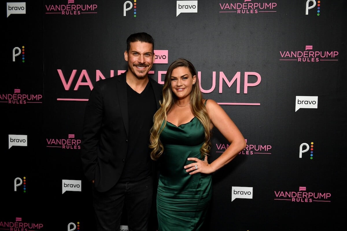 Jax Taylor and Brittany Cartwright pose in front of a 'Vanderpump Rules' backdrop