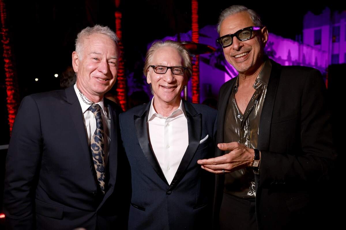 Tennis star John McEnroe, host Bill Maher, and actor Jeff Goldblum pose together in dark suits