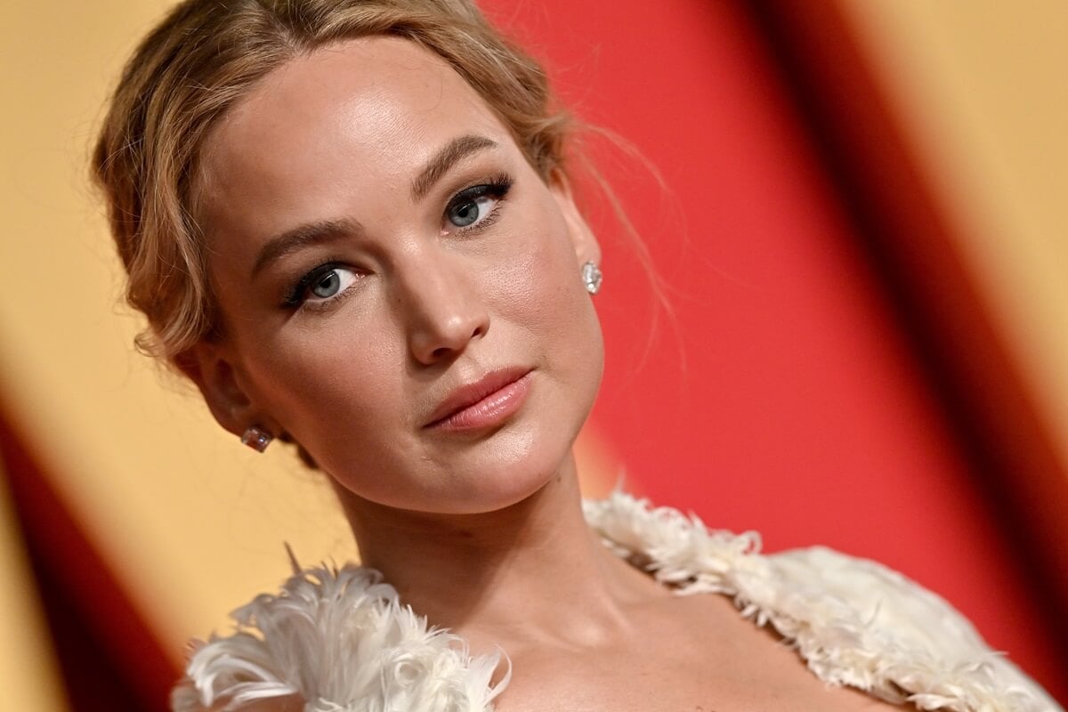 Jennifer Lawrence posing in a white dress at the 2024 Vanity Fair Oscar Party.