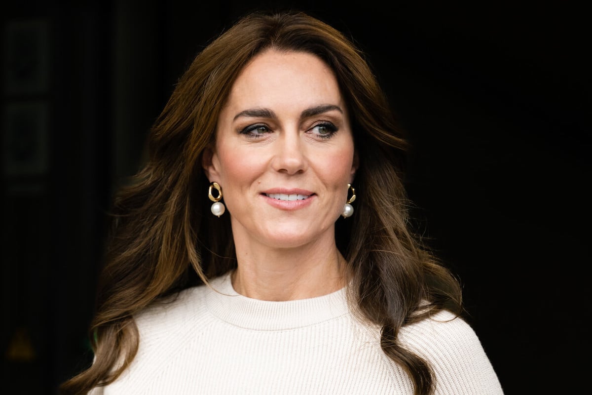 Kate Middleton, whose first public appearance since abdominal surgery has been scheduled, looks on wearing a white top