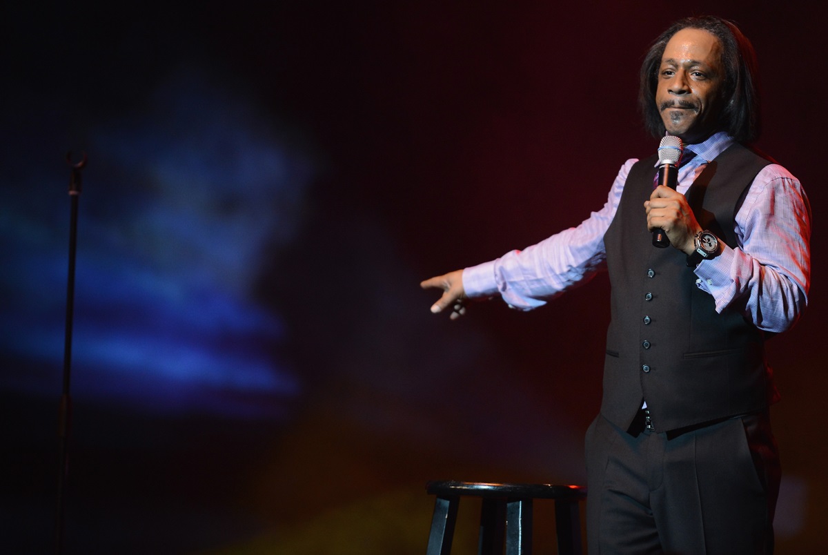 Katt Williams performing on stage while wearing a purple and black suit.