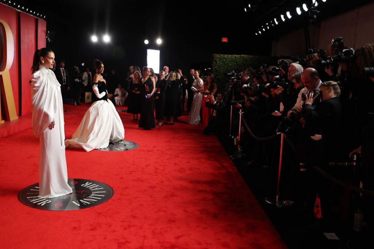 Singer Kelly Rowland wears a black and white gown and poses for cameras next to model Alessandra Ambrosio on the red carpet before the Vanity Fair Oscars party