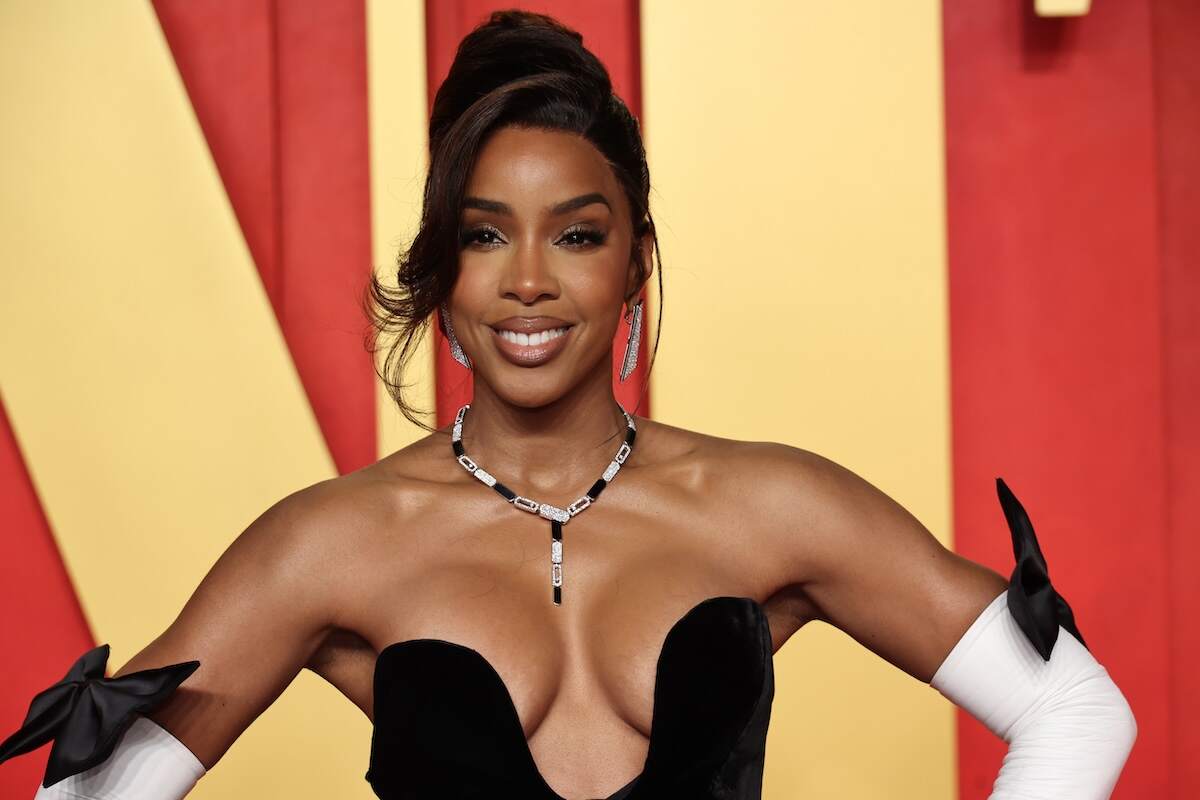 Singer Kelly Rowland wears a black and white gown and poses on the red carpet before the Vanity Fair Oscars party