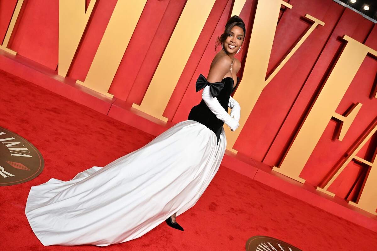 Singer Kelly Rowland wears a black and white gown and poses on the red carpet before the Vanity Fair Oscars party