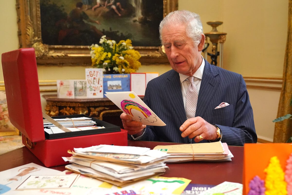 King Charles III, who reportedly plans on attending events including Trooping the Colour, Easter, garden parties, and the Royal Ascot, looks at cards