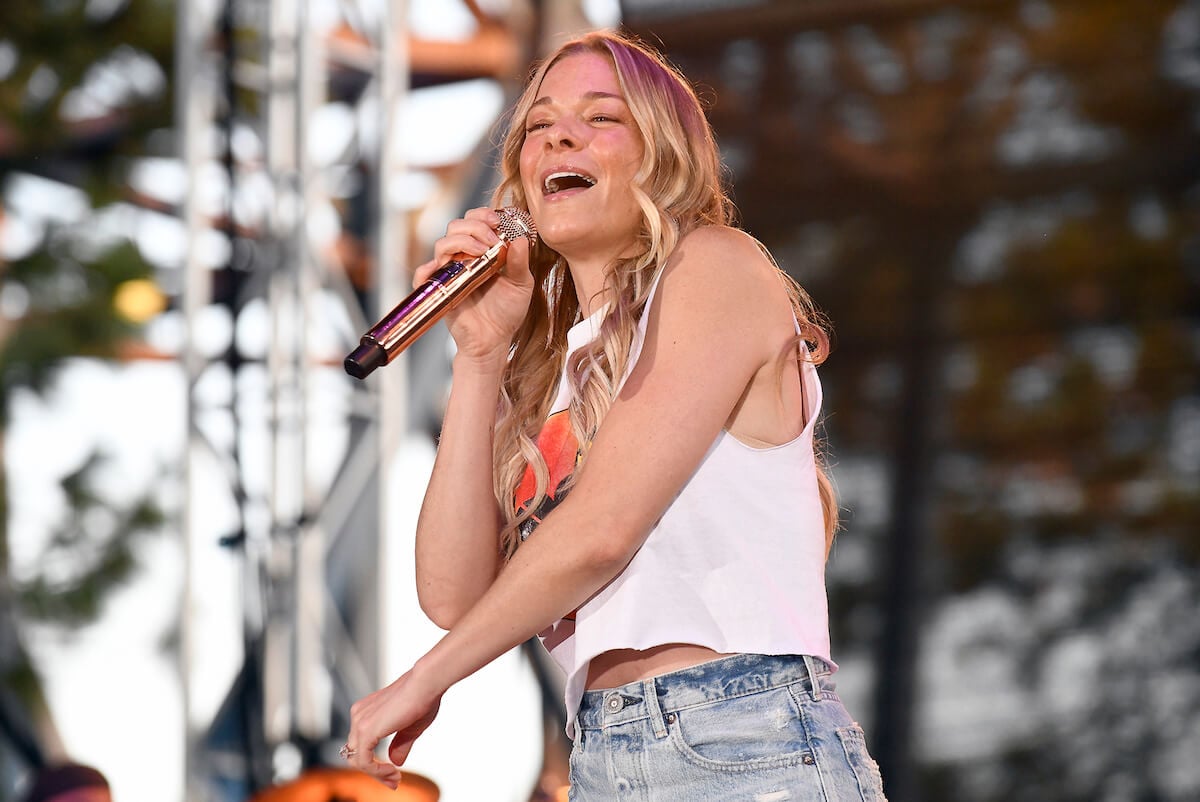 LeAnn Rimes singing and smiling into a microphone outdoors