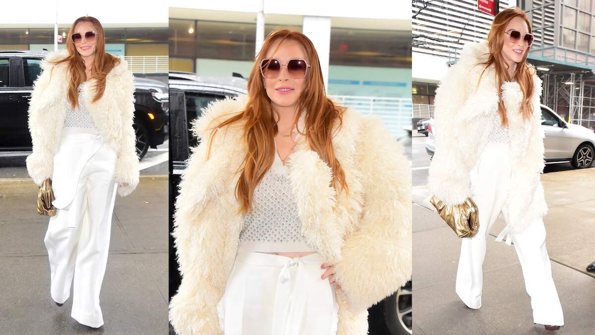 Actor Lindsay Lohan smiles at paparazzi as she wears a white outfit and fur coat in NYC