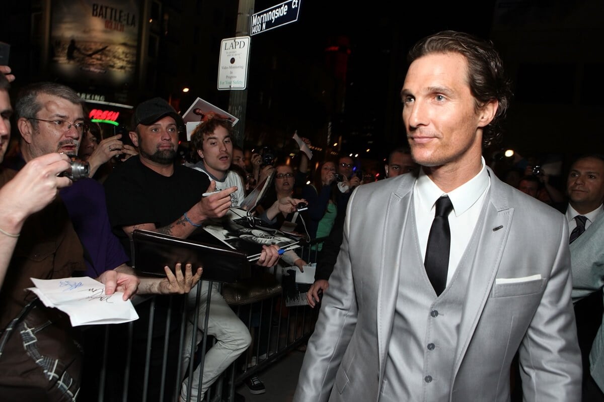 Matthew McConaughey posing in a silver suit at the premiere of the 'Lincoln Lawyer'.