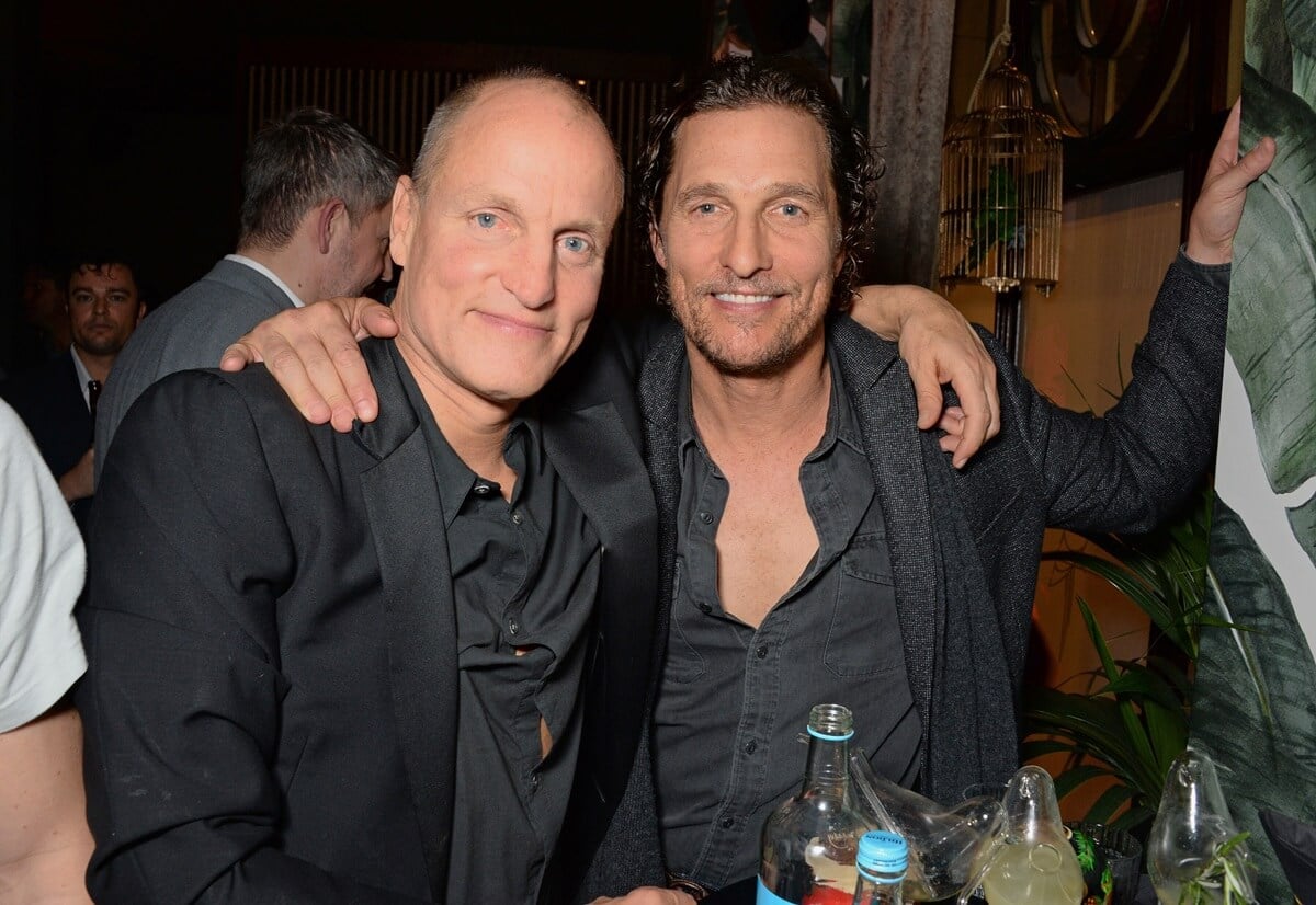 Woody Harrelson and Matthew McConaughey hugging each other in black suits.