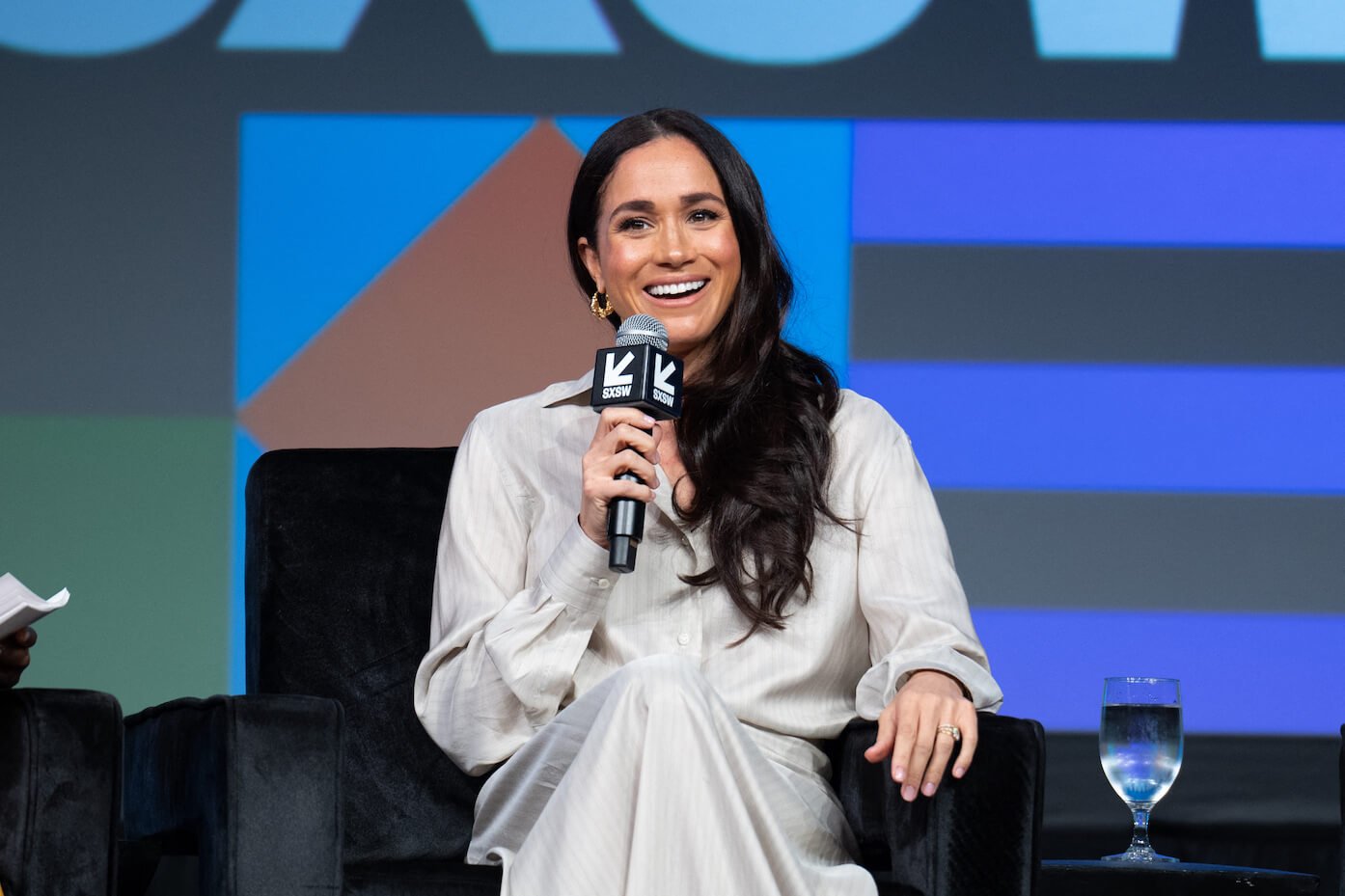 Meghan Markle sitting in a chair speaking into a microphone at an event in 2024