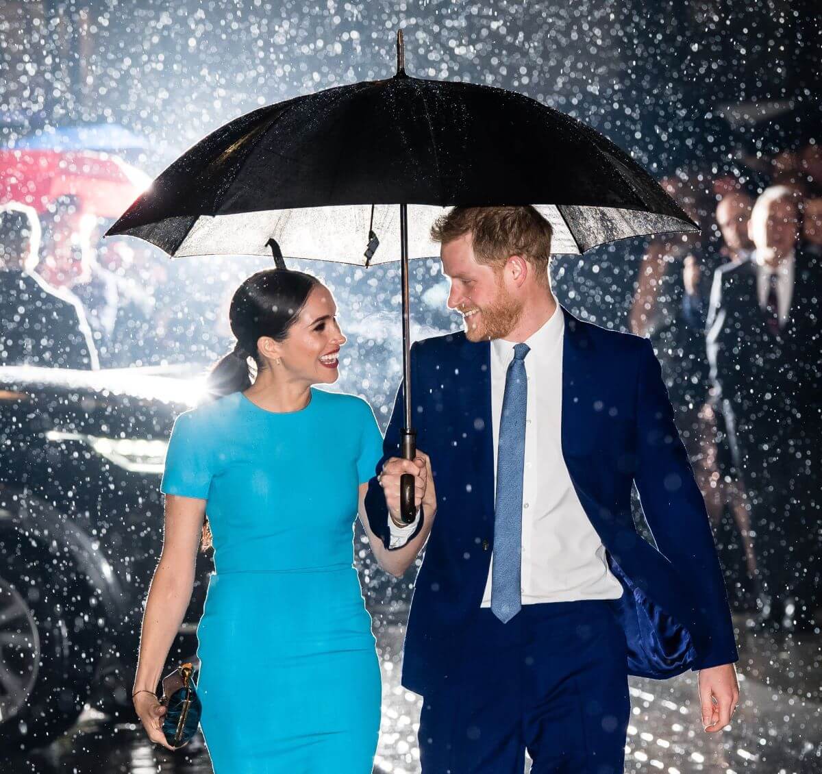 Meghan Markle and Prince Harry smiling under umbrella as they arrive at The Endeavour Fund Awards in London
