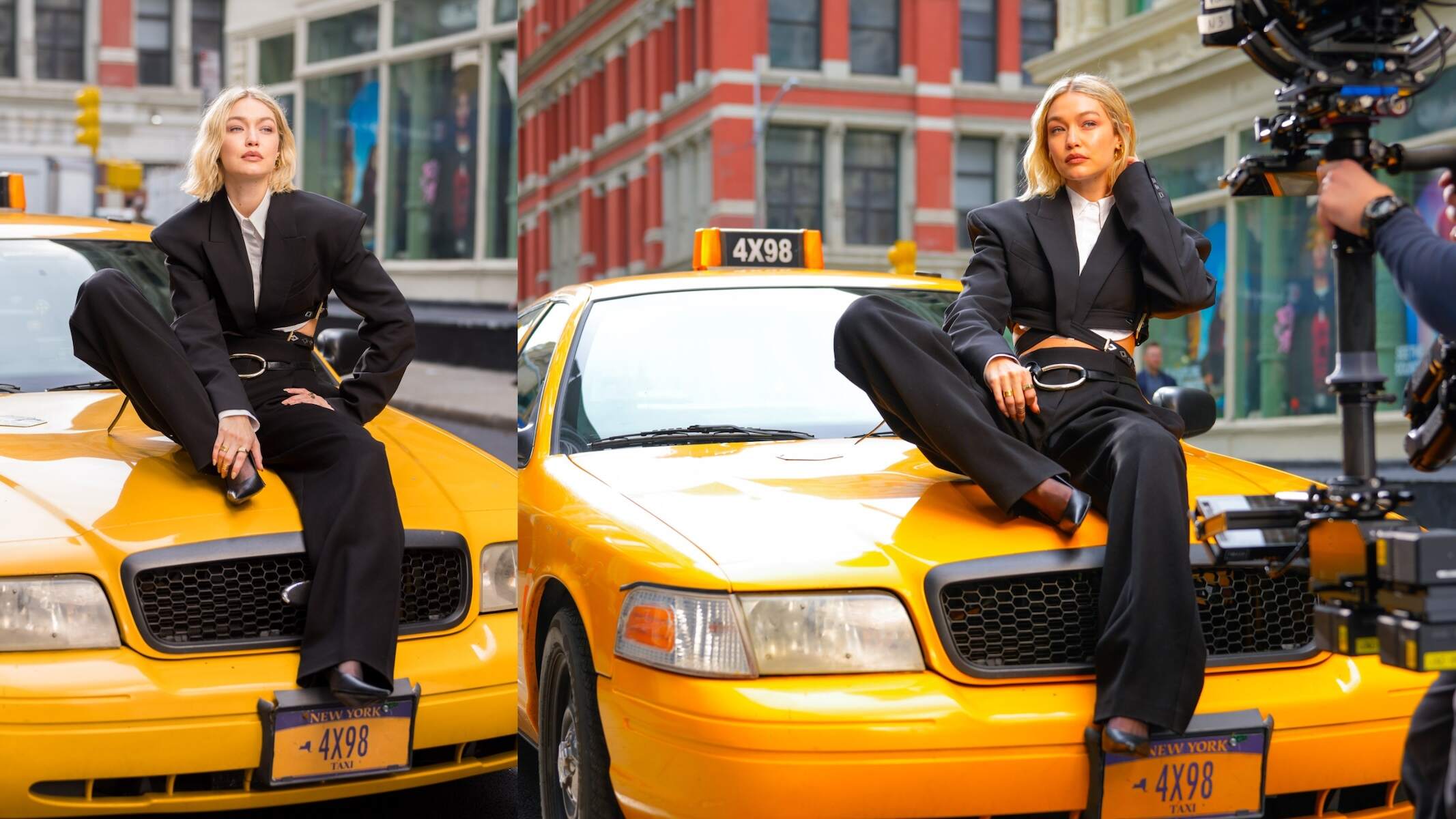 Model Gigi Hadid wears a black jacket and pants and sits on a taxi while filming a video for Maybelline on a NYC street