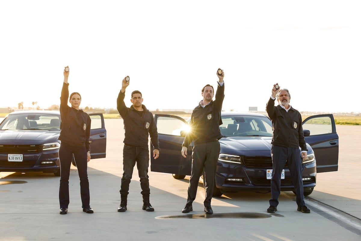 Four NCIS agents holding up their badges