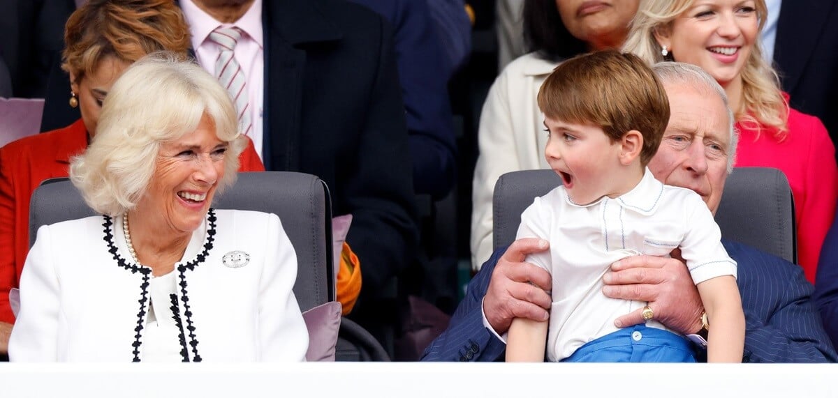 Queen Camilla smiling as Prince Louis of Cambridge sits on his grandfather King Charles' lap