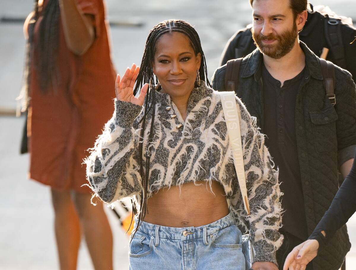 Wearing baggy jeans and a crop top, Regina King waves to fans while walking in NYC