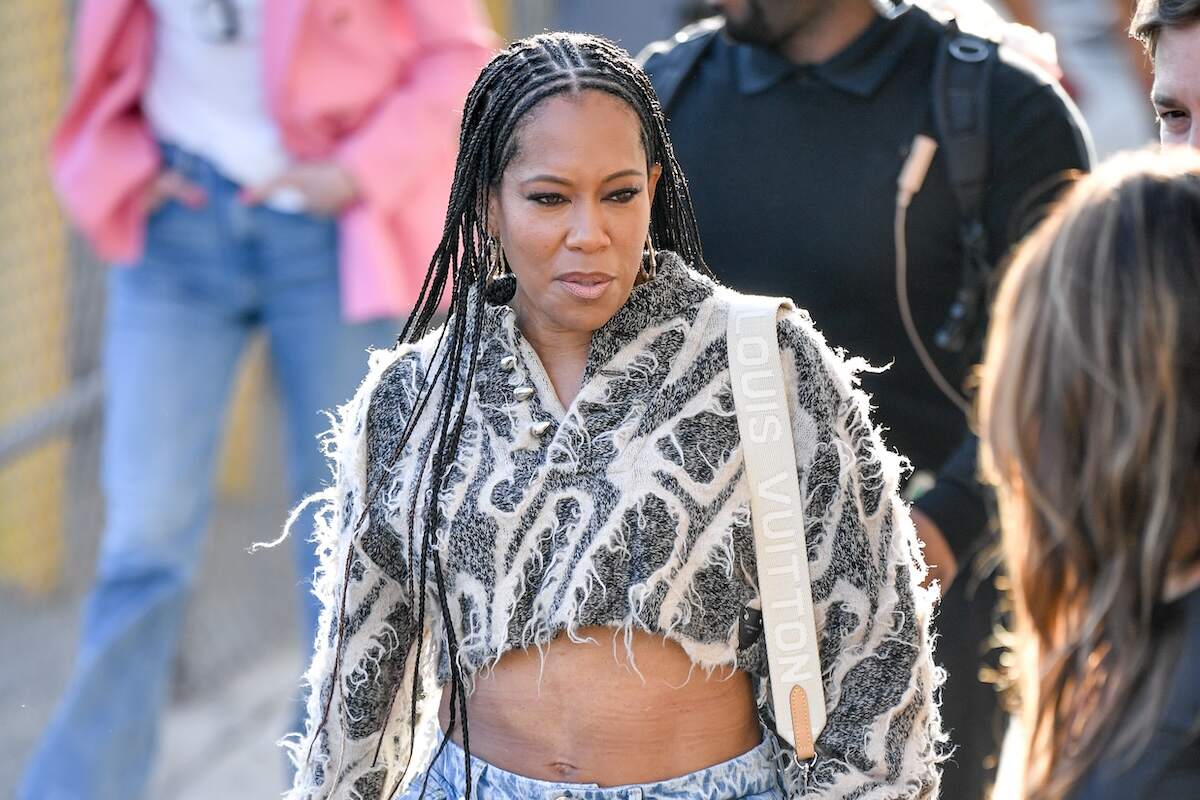 Wearing baggy jeans and a crop top, Regina King waves to fans while walking in NYC