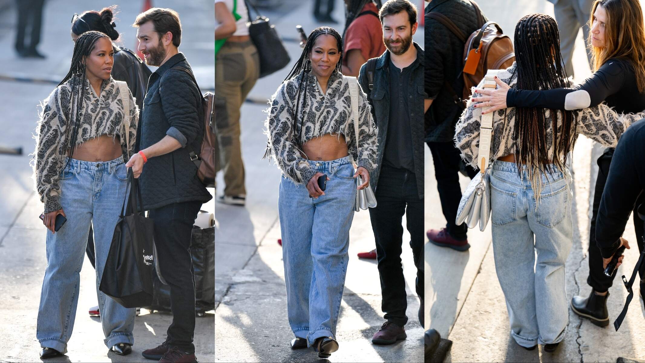 Wearing baggy jeans and a crop top, Regina King speaks to her team while walking in NYC