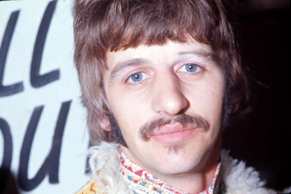 A close up of The Beatles' Ringo Starr wearing a jacket with a fur collar.