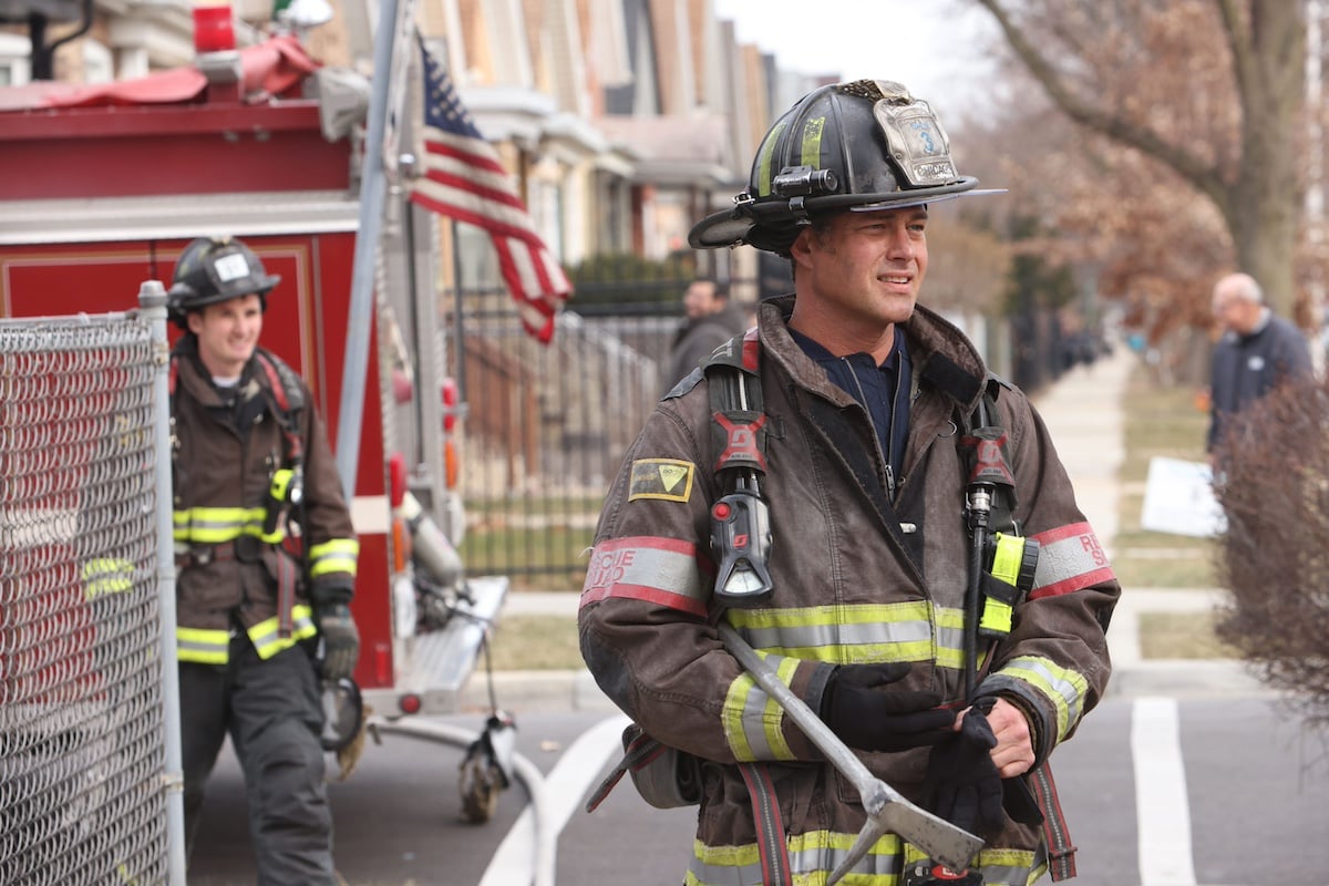 Kelly Severide, wearing firefighting gear and standing next to a firetruck, in 'Chicago Fire'
