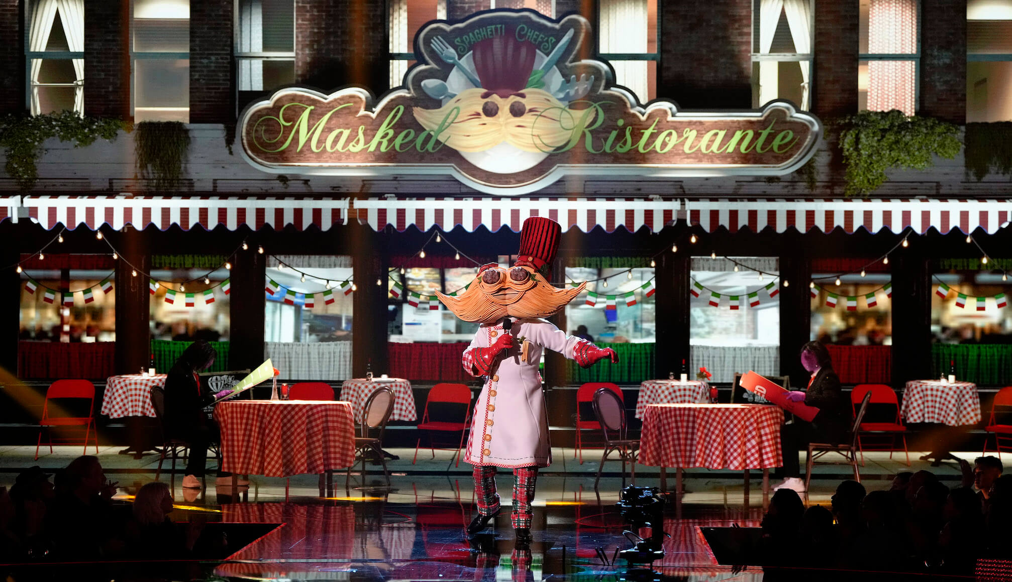Spaghetti and Meatballs singing on 'The Masked Singer' Season 11 while surrounded with Italian restaurant decor