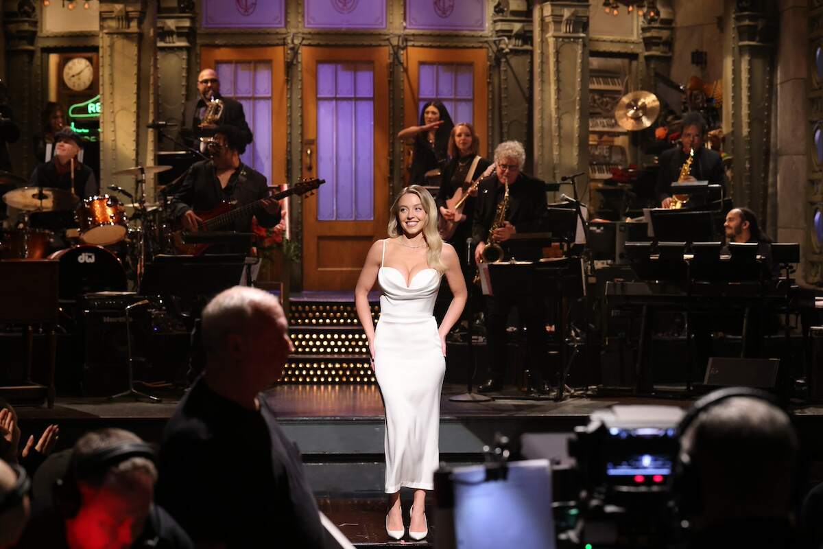 Sydney Sweeney smiles during her 'Saturday Night Live' monologue while wearing a white dress