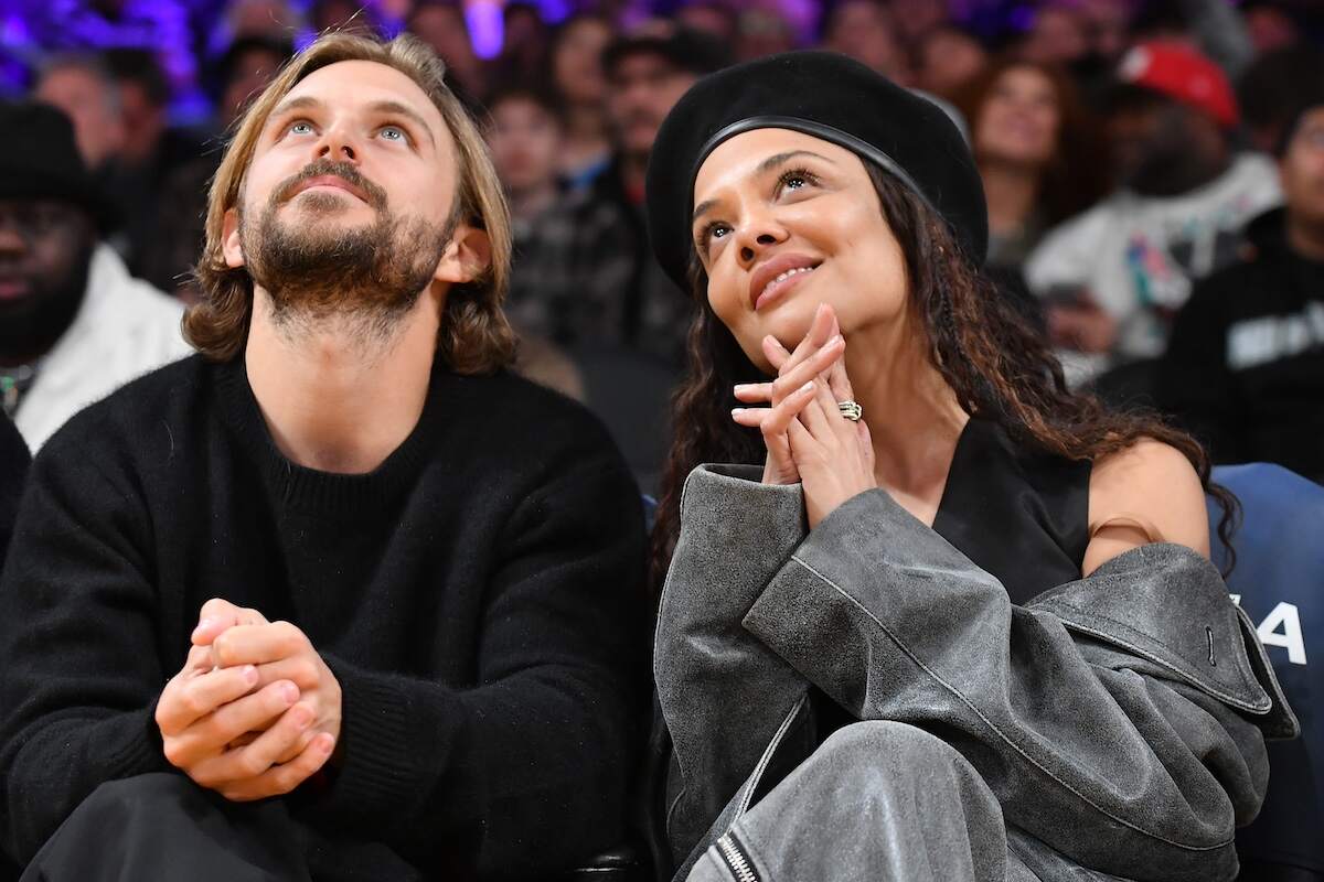 Actor Tessa Thompson and socialite Brandon Green look up at the scoreboard during a Lakers game