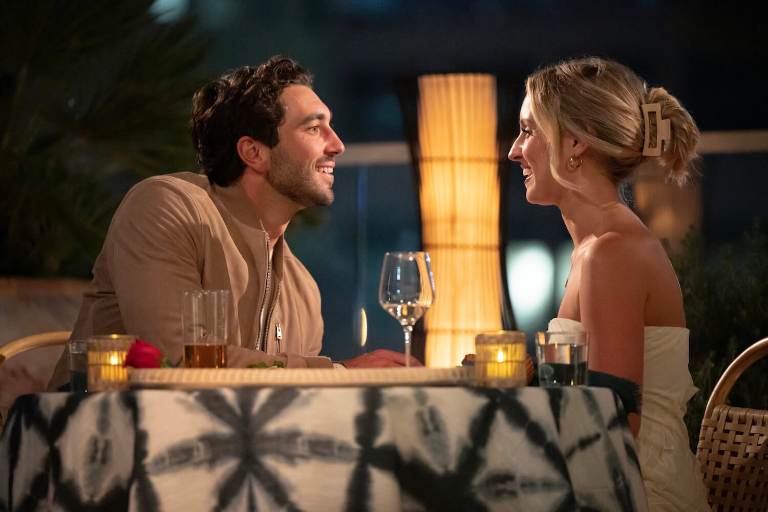 'The Bachelor' Season 28 lead Joey Graziadei speaking to Daisy Kent and smiling from across a round dinner table