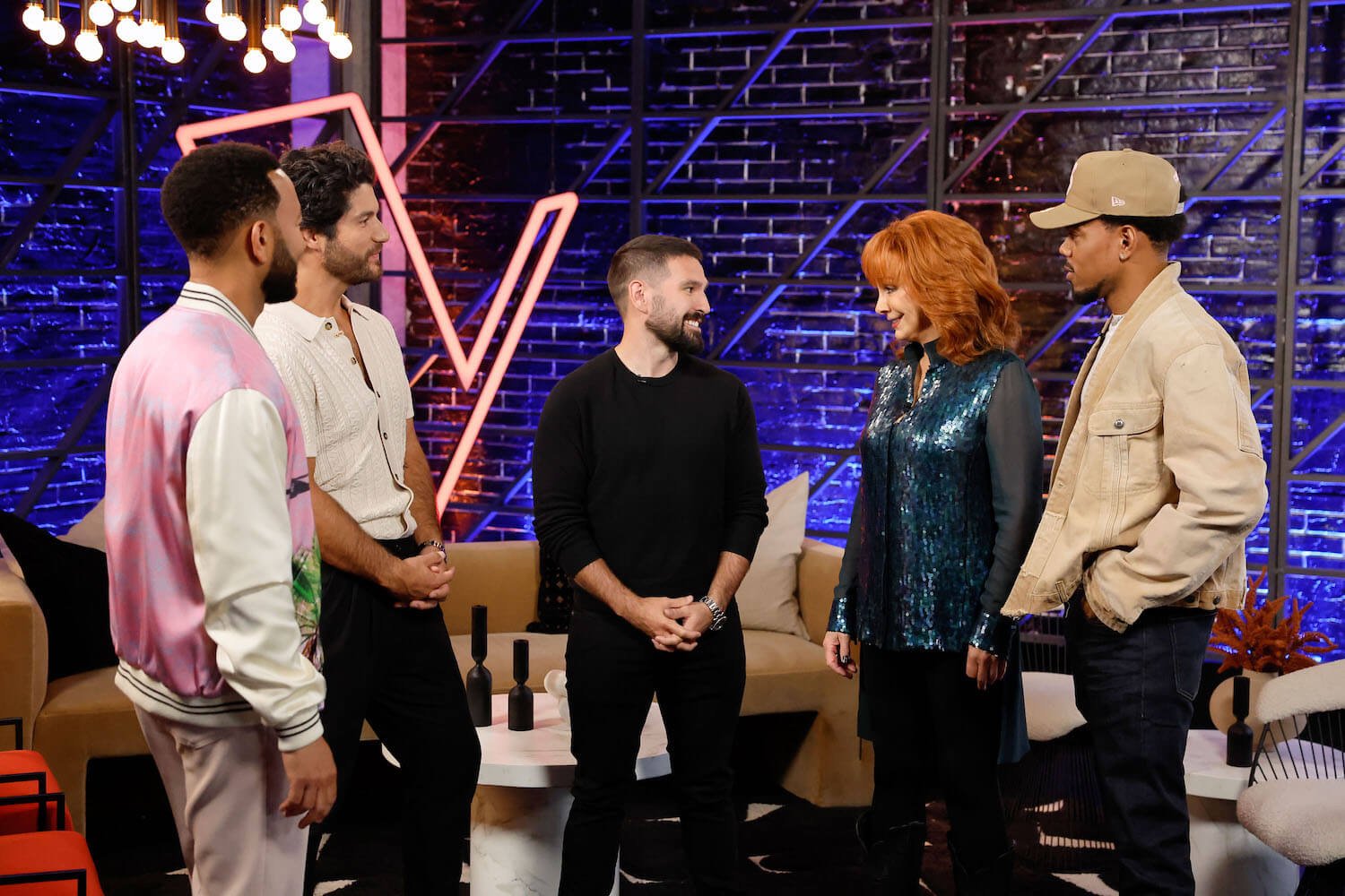 'The Voice' Season 25 coaches John Legend, Dan + Shay, Reba McEntire, and Chance the Rapper standing and talking to each other on the set of the show