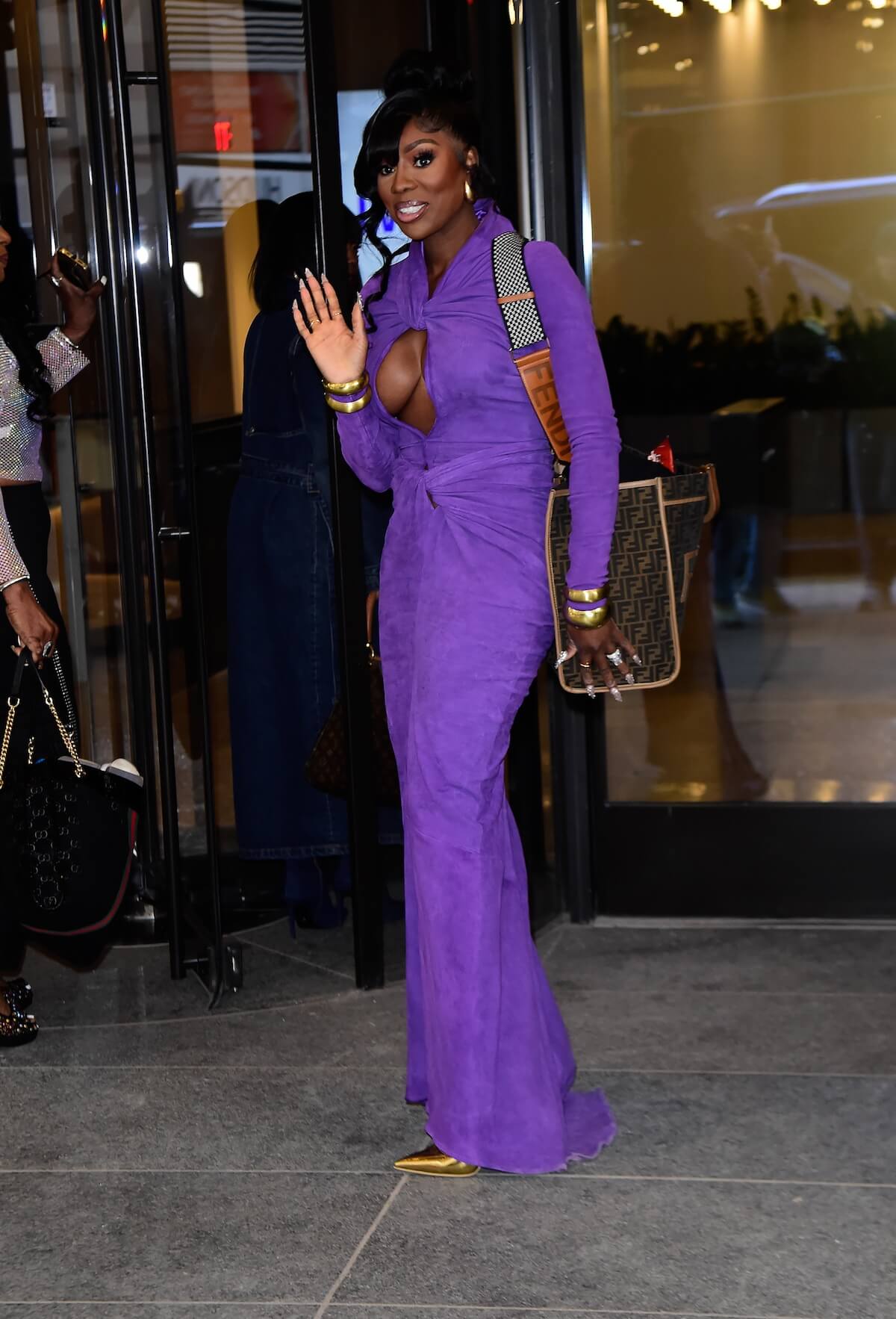 Wendy Osefo waving in a purple dress